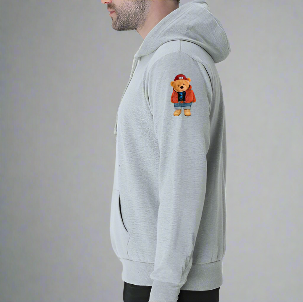 A man in a grey hoodie featuring a bear graphic, casually posing with a relaxed expression.